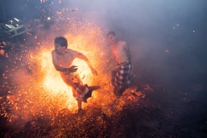Balinese men hit each other using burnt coconut husks during the fire fight ritual.
