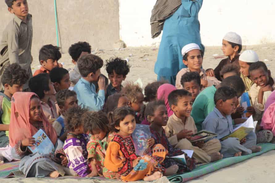 Children in Abdul Rahim Bazar read books brought brought by the camel library