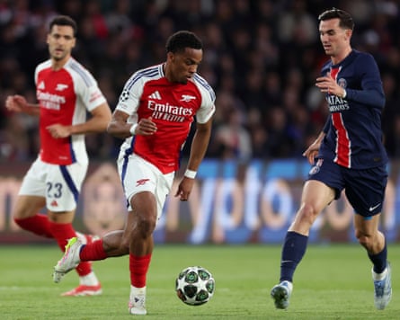 Arsenal defender Jurriën Timber runs with the ball and prepares to receive a tackle from Paris Saint-Germain midfielder Fabián Ruiz during the 2025 Champions League semi-final second leg at the Parc des Princes in Paris.