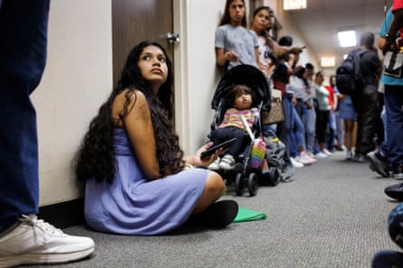 Yolexi Cubillan, 19, sits on the floor while waiting in line with other migrants at an Illinois Department of Human Services office on 28 August in Chicago.