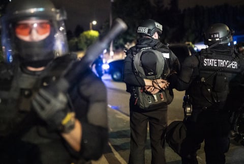 An Oregon State Trooper arrests a journalist during a crowd dispersal near the Portland east police precinct on August 30 in Portland, Oregon.