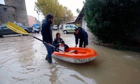 People get on a small boat in a flooded street after heavy rains in Le Muy, southeastern France, on 24 November. France is among many European nations criticised for not doing enough to phase out fossil fuel subsidies.