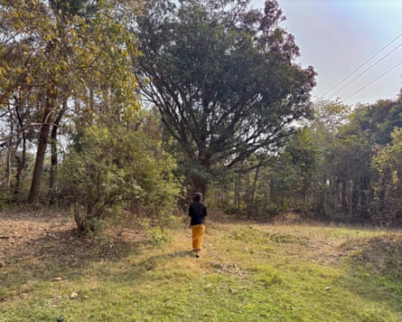 Monsumi Murmu walks through the forest.