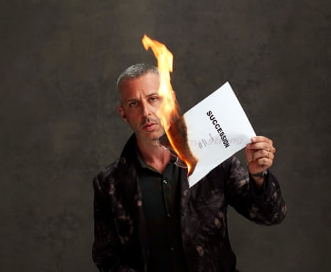 Jeremy Strong holding a burning page of the Succession script