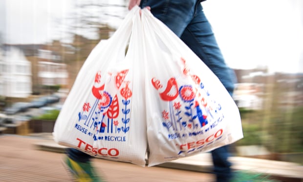 A shopper carrying Tesco bags