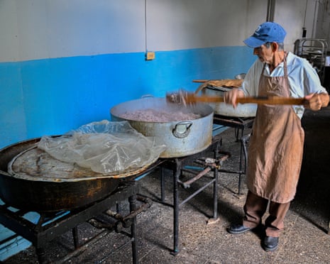 A man prepares food in large tin basins
