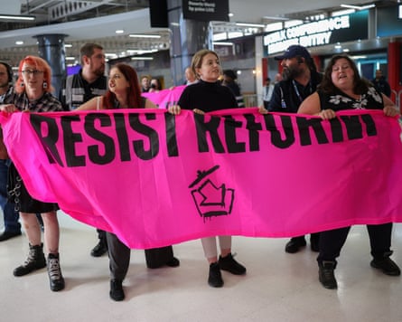 A group of climate protesters brandish a pink sign that says ‘Resist Reform’