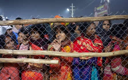 Devotees are stopped by police officers after a deadly crowd crush