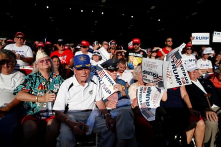 People listen to Trump speak at a campaign rally