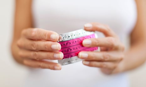 Woman's hand holding birth control pills,
