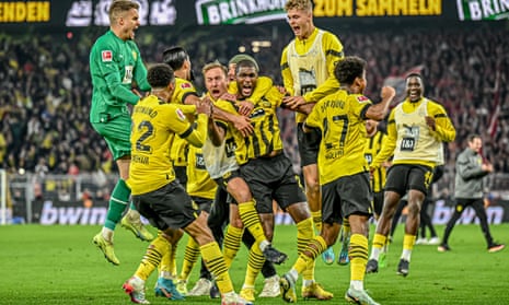 Anthony Modeste (centre) is mobbed by his Dortmund teammates after scoring a late equaliser in the 2-2 draw with Bayern Munich.