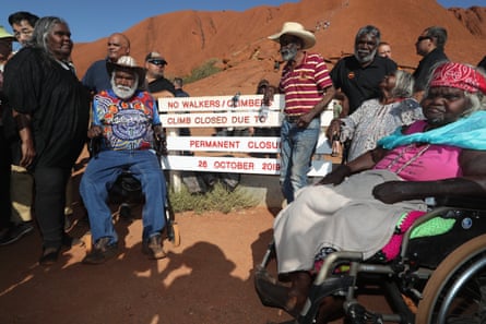 Traditional owners gather around the base of the Uluru climb after it was permanently closed on Friday evening.