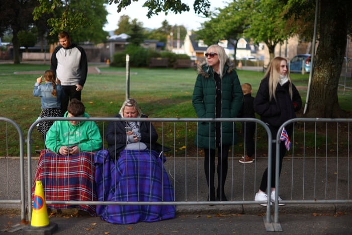 People on the street waiting for the funeral cortege in Ballater, Scotland.