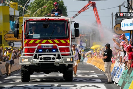 French firefighters spray the crowd on the finish line to cool off