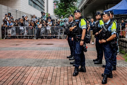 Police officers stand near the media area outside the West Kowloon Magistrates' Courts ahead of the court’s verdict.