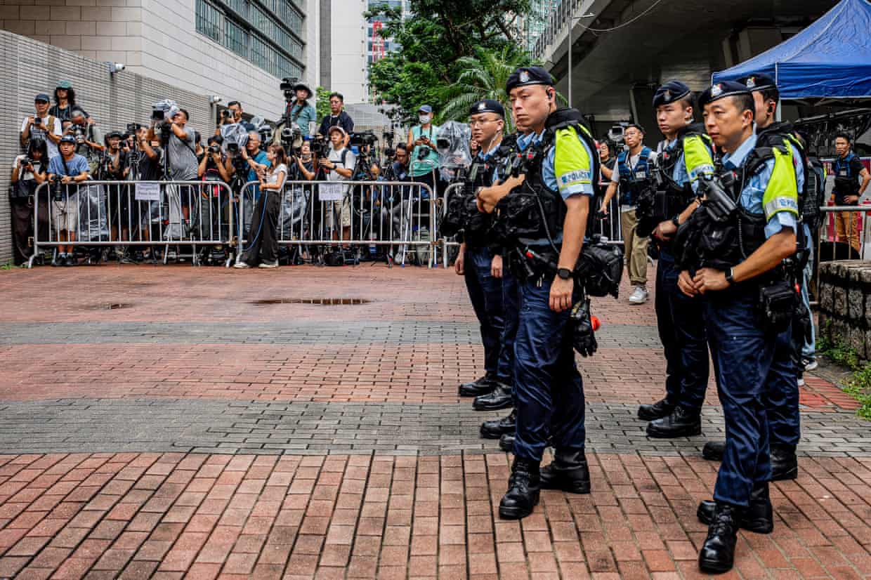 Police officers stand near the media area outside the West Kowloon Magistrates' Courts ahead of the court’s verdict.