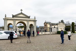 Relatives keep a safe distance from the coffin while gathering for a funeral ceremony outside the small cemetery of Bolgare, Lombardy