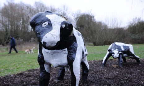 A dog walker passes The Concrete Cows sculpture