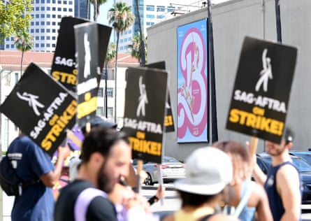 Members of the WGA and Sag-Aftra walk a picket line outside of the Warner Bros studio in Burbank, California, on 26 July 2023.