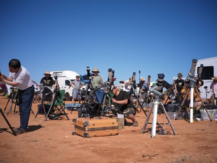 People setting up telescopes and camera equipment.