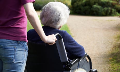 Woman pushing an older woman in a wheelchair.