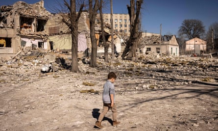 A children walks in front of a ruined school in the city of Zhytomyr, northern Ukraine, in March.