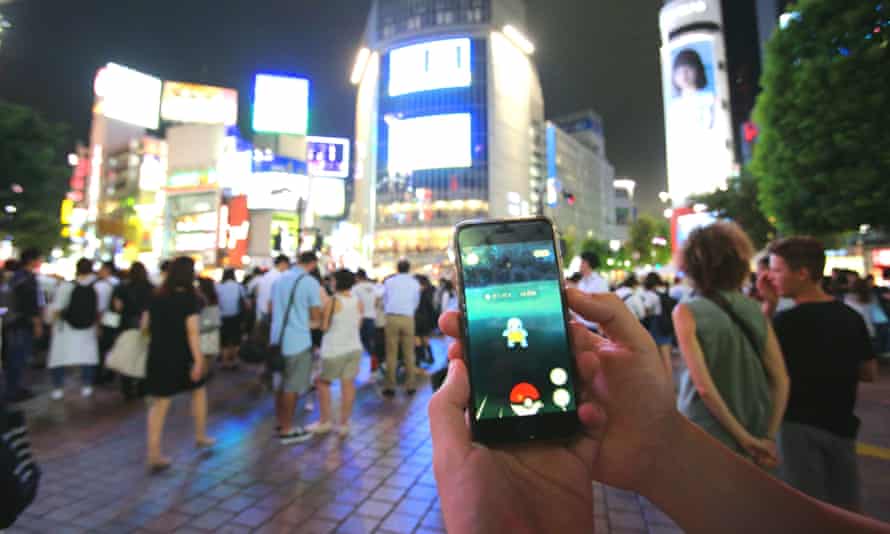 Big in Japan … people play Pokémon Go on their smartphones in Shibuya district, Tokyo.