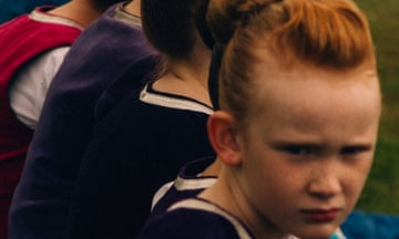 A girl with ginger hair looks to her right.