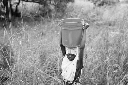 Ajida Patricio, 14, walks home with water in Mococorene, Nampula province