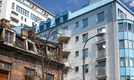 An old tenement building, with a modern apartment block behind.