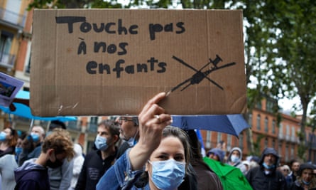 A woman holds a cardboard sign reading: ‘Don’t touch our children’ at a protest in Toulouse last month