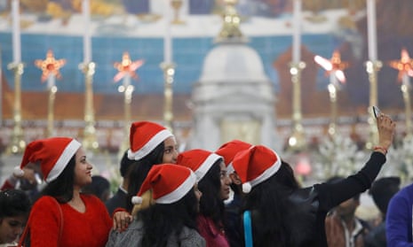 Worshippers in Santa Claus hats take a selfie during Christmas celebrations at a church in Delhi