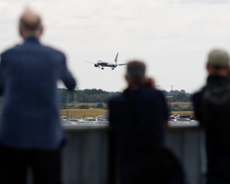 Bystanders watch the plane carrying the England squad land.
