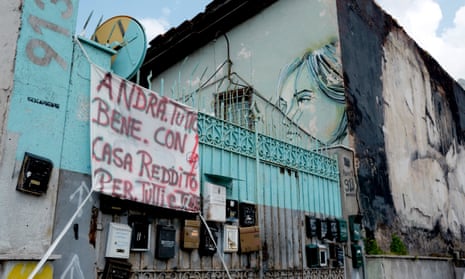 A sign on a building occupied by dozens of homeless families in Rome reads: ‘Everything will be fine with income and homes for all’