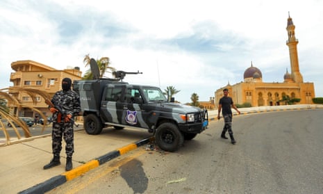 Security forces affiliated with the Libyan Government of National Accord stand at a makeshift checkpoint in Tarhuna