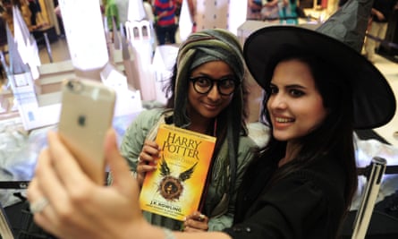 A girl takes a selfie wearing a witch’s hat and holding a copy of Harry Potter and the Cursed Child in 2016.