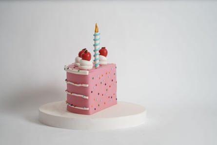 A cute pink half birthday cake with candle and cherries on a white background