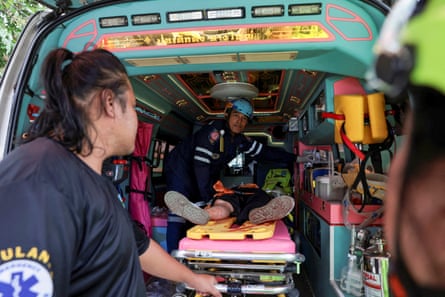 An injured teacher receives medical attention inside an ambulance