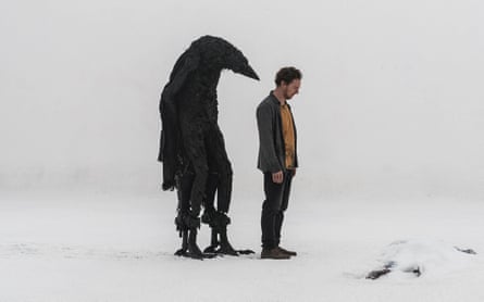 A giant crow stands behind a man in a snowy landscape