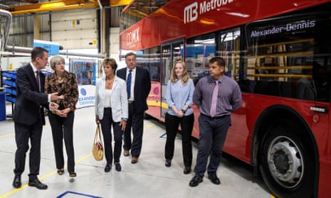 Theresa May and other people at a bus factory