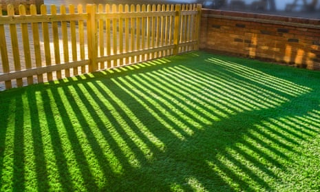 garden with artificial grass as a lawn and a red brick perimeter wall.