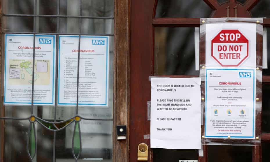 Notices on a GP surgery tell people who think they may be infected to go home and seek NHS advice online.