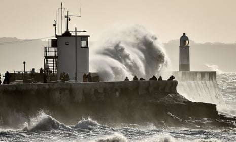 People watch as huge waves hit the sea wall in Porthcawl, South Wales