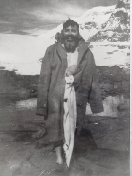 Black and white photo of George Barry after a swim with snowy mountains in the background