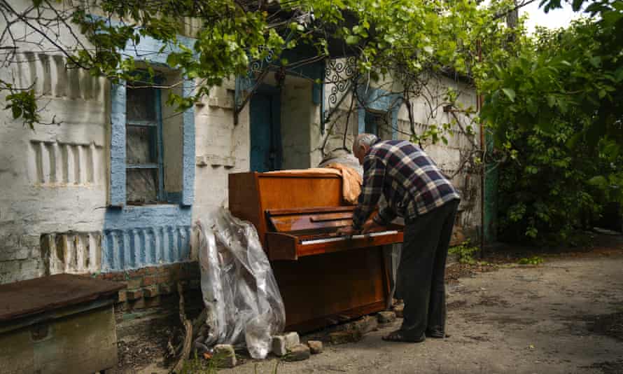 Local resident Anatolii Virko plays a piano outside a house likely damaged after a Russian bombing in Velyka Kostromka village, Ukraine.