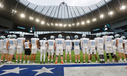 The NFL Academy players line up to shield their warm up from the opposition before their match against De La Salle Spartans from California at the Tottenham Hotspur Stadium.