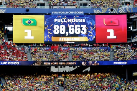 A big screen displays the match attendance
