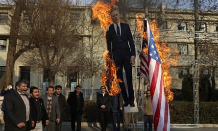 Protesters set fire to US and British flags and a life size cut-out of the the UK’s ambassador Rob Macaire in Tehran on Tuesday.