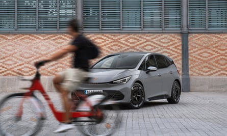 Um ciclista passa por um CUPRA Born