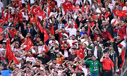 Turkish football fans in Paris respond to the players with their own military salutes.
